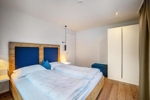 a bedroom with a large bed with a blue headboard at Stoana Apt 3-4 in San Giacomo