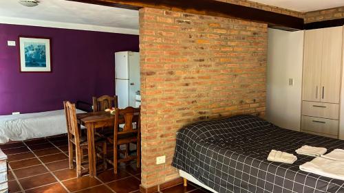 圣罗莎卡拉穆奇塔县Hospedaje Frente al Rio el Rancho的卧室设有砖墙、一张床和一张桌子