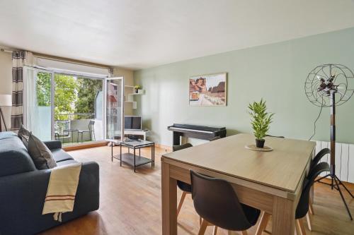 un salon avec une table et un canapé dans l'établissement Appartement Chic avec terrace et parking, à Sartrouville