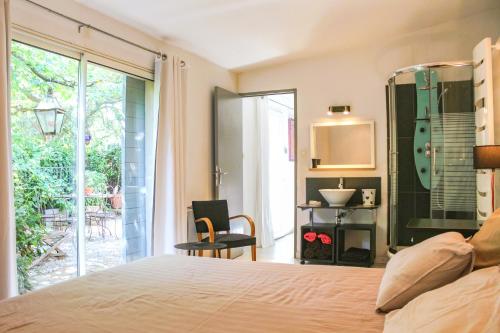 une chambre avec un lit et une porte coulissante en verre dans l'établissement Mas Provençal avec piscine., à Grans