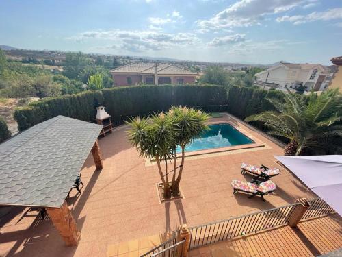 a backyard with a swimming pool and palm trees at Villatrajín in Otura