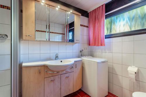 a bathroom with a sink and a washing machine at Ferienhaus Vorauf - Föttinger in Molberting