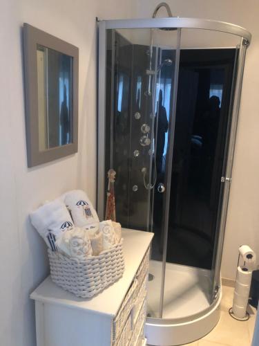 uma casa de banho com um chuveiro e uma cesta de toalhas em Chambre d hôte à la plage LE MANAPANY em Camiers