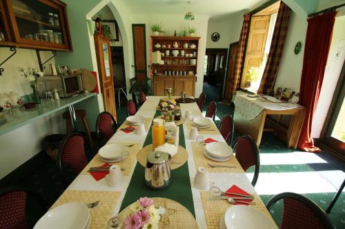 a dining room with a long table and chairs at Over the Rainbow - Vegetarian Guesthouse in Blaenporth