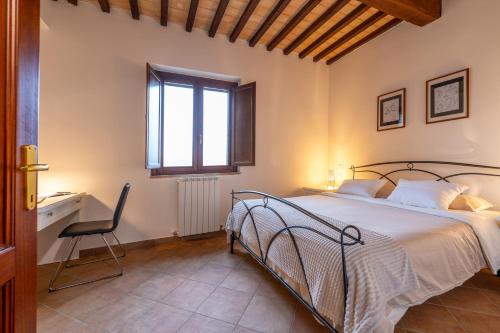 una camera da letto con un letto, una sedia e una finestra di Casale Corciano a Ellera