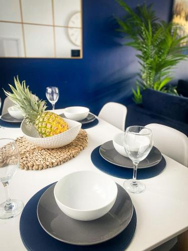 a table with plates and glasses and a pineapple on it at Phoenix House - 2 Double Bedroom House - Business and Corporate Travellers in Luton