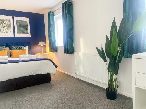 a bedroom with a bed and a potted plant at Phoenix House - 2 Double Bedroom House - Business and Corporate Travellers in Luton