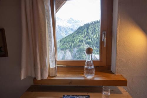 a bottle sitting on a window sill with a view at Chasa Rosa in Vna