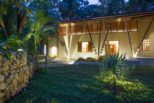 a house with a stone wall in front of a yard at Shawandha Villas in Punta Uva