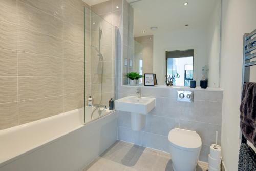 La salle de bains est pourvue de toilettes, d'un lavabo et d'une douche. dans l'établissement Stevenage Luxury 1 Bed Apartment Sleeps 4 WIFI Free Parking Secure by JM Short Lets, à Stevenage