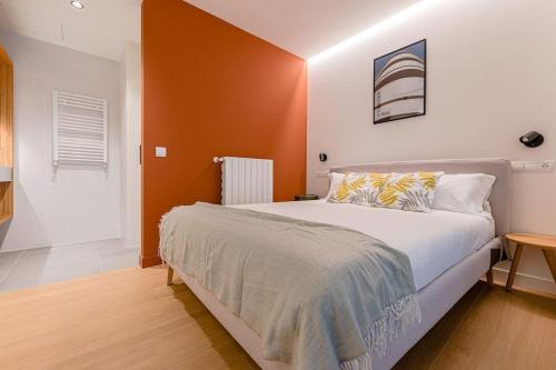 ein Schlafzimmer mit einem großen Bett mit orangefarbenen Wänden in der Unterkunft Hermoso estudio en Legazpi °2 in Madrid