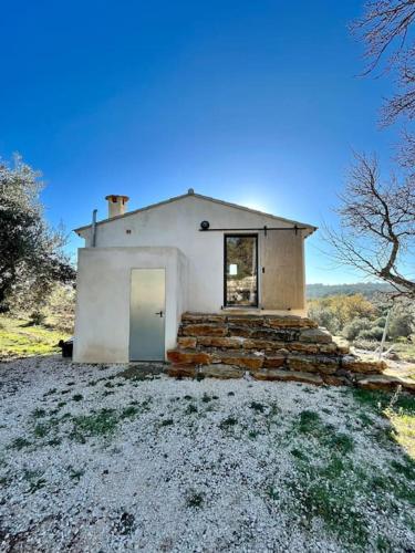 une petite maison blanche avec une porte dans un champ dans l'établissement Cabanon Provençal, à Cuers