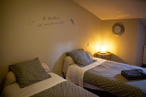 um quarto com duas camas e uma placa na parede em auberge du marronnier em Belmont-sur-Rance