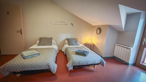 um quarto com duas camas e uma cruz na parede em auberge du marronnier em Belmont-sur-Rance