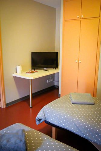 um quarto com uma secretária e uma mesa com uma cama em auberge du marronnier em Belmont-sur-Rance