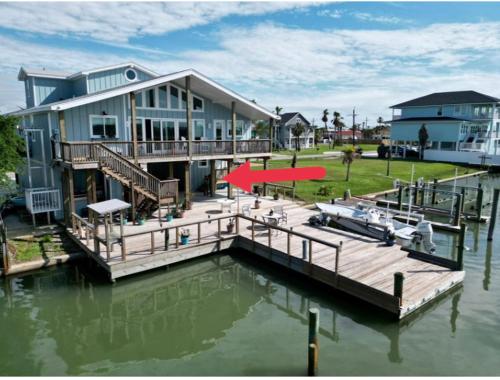 a large house with a dock on the water at Waterfront Guesthouse on Key Allegro/Little Bay with dock in Rockport