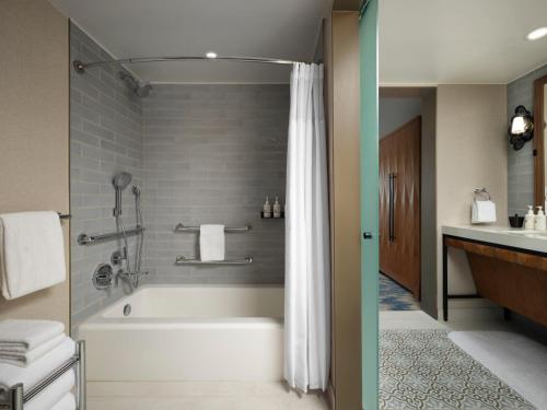 a bathroom with a bath tub and a sink at Plaza San Antonio Hotel & Spa, Autograph Collection in San Antonio