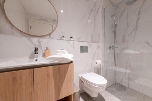 uma casa de banho com um WC, um lavatório e um espelho. em The Princess Apartment no Funchal