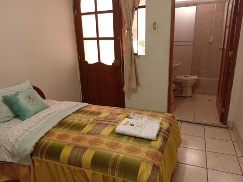 1 dormitorio con 1 cama y baño con aseo en Hostal Turismo Cruz de Piedra EIRL-Cajamarca, en Cajamarca