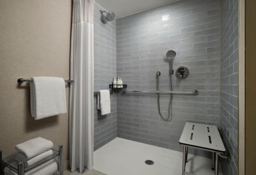 a bathroom with a shower with blue tiles at Plaza San Antonio Hotel & Spa, Autograph Collection in San Antonio