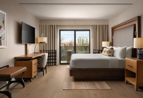 a hotel room with a bed and a desk and a window at Plaza San Antonio Hotel & Spa, Autograph Collection in San Antonio