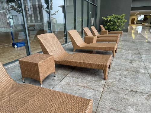 a row of wicker chairs and tables in a building at SKS PAVILLION Cozy Studio With Netflix WiFi Car Park in Johor Bahru
