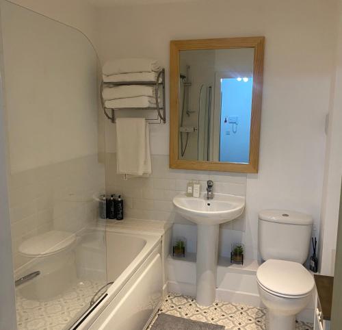 een badkamer met een wastafel, een toilet en een bad bij Shepshed 2 Bedroom Apartment in Shepshed
