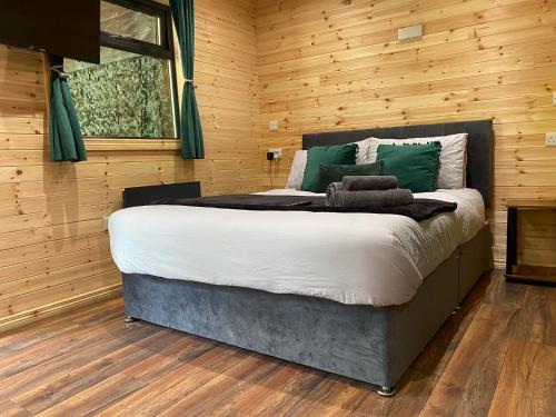 um quarto com uma cama grande numa parede de madeira em The Secret Garden - Hot Tub North Coast Stay em Garvagh