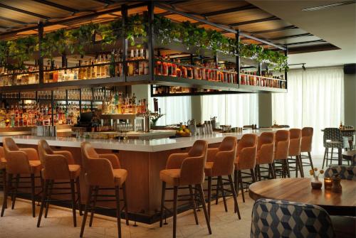 a bar with orange chairs at a restaurant at Plaza San Antonio Hotel & Spa, Autograph Collection in San Antonio