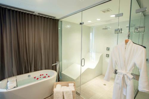 奧克布魯克的住宿－芝加哥- 奧克布魯克中心艾美度假酒店，带浴缸和玻璃淋浴间的浴室。