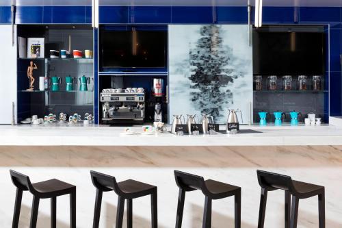 a bar with black stools in front of a counter at Le Méridien Chicago - Oakbrook Center in Oak Brook