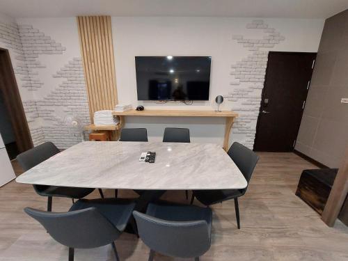 a conference room with a table and chairs and a television at 清境依山舞林民宿 in Renai