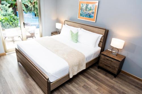ein Schlafzimmer mit einem Bett und einem Tisch mit einer Lampe in der Unterkunft Garden Oasis 1 Villa With Private Pool in Four Roads