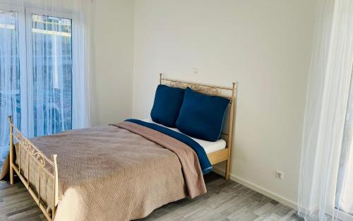 a bedroom with a bed with blue pillows and a window at Apartment Weikersheim I in Weikersheim