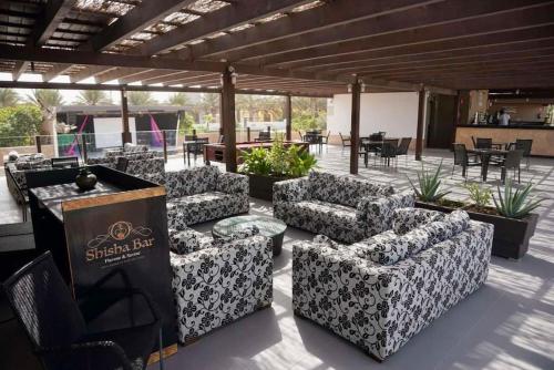 un patio con sofás, mesas y sillas en Residência Oceaníca Meliá Dunas Beach Resort & Spa, en Santa Maria