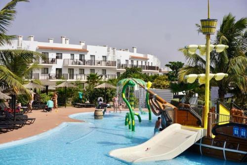 una piscina con un tobogán en un complejo en Residência Oceaníca Meliá Dunas Beach Resort & Spa, en Santa Maria