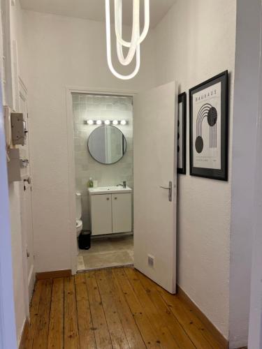 - un couloir avec une salle de bains pourvue d'un lavabo et d'un miroir dans l'établissement Centre Historique Les toit du MOCO, à Montpellier