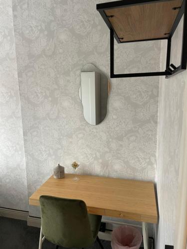 a table with a chair and a mirror on a wall at Villa Lyckan in Söråker