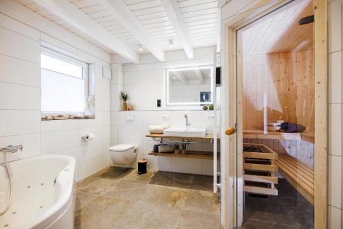 een badkamer met een wastafel, een bad en een toilet bij Vechteufer in Nordhorn