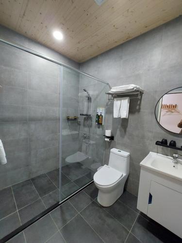 a bathroom with a shower and a toilet and a sink at 清境依山舞林民宿 in Renai