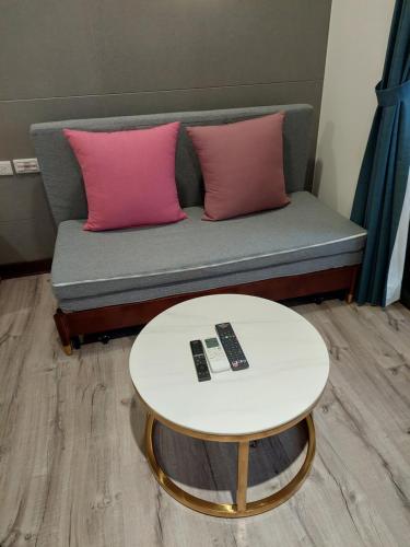 a couch with two pink pillows and a table at 清境依山舞林民宿 in Renai