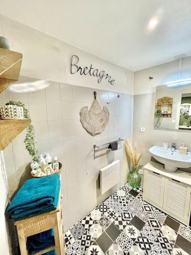 ein Bad mit einem schwarz-weißen Fliesenboden in der Unterkunft Le Cottage Breton, hypercentre historique StB in Saint-Brieuc