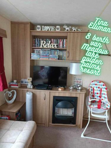 a living room with a tv and a fireplace at Tina's caravan hire in Chapel Saint Leonards