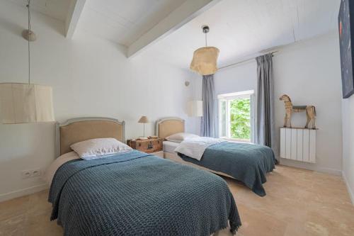 1 dormitorio con 2 camas y ventana en LA SUITE D’AMOUR Cucuron : une maison de village. en Cucuron