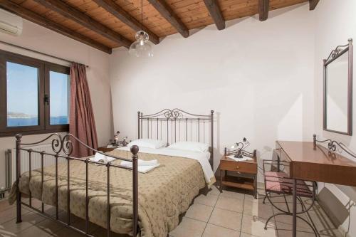 a bedroom with a bed and a dresser and a desk at Villa Aptera in Kalami