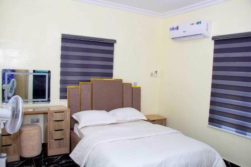 a bedroom with a bed and a desk with a computer at Delkiks Four-Bedroom Haven. in Lagos