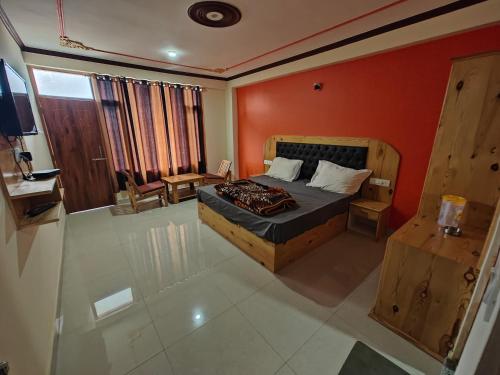 - une chambre dotée d'un lit avec un mur orange dans l'établissement Aleo Villa, à Manali