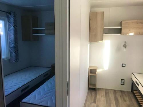 a small room with a bed and a small table at Bungalow charmant à Canet-en-Roussillon avec piscine in Canet-en-Roussillon