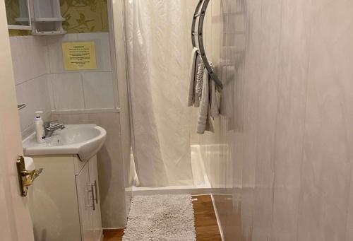 y baño con ducha y lavamanos. en Barramore Holiday Apartments en Torquay