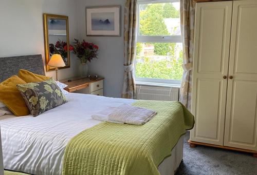 Un dormitorio con una cama grande y una ventana en Barramore Holiday Apartments, en Torquay